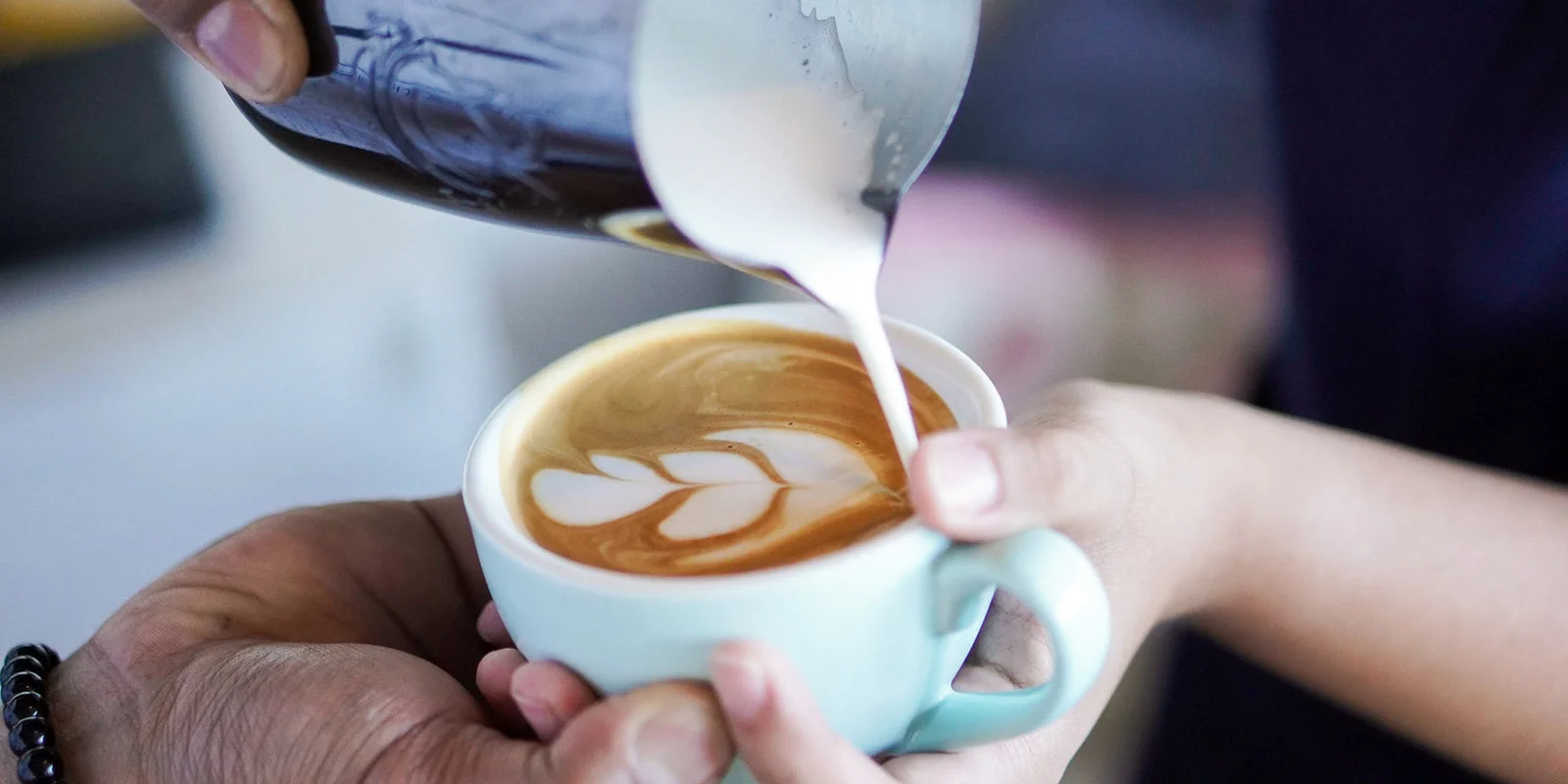 Milk being poured into coffee during a Brewing Club barista class